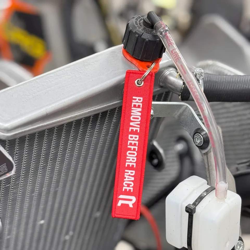 Radne Remove Before Race sangle radiateur rouge