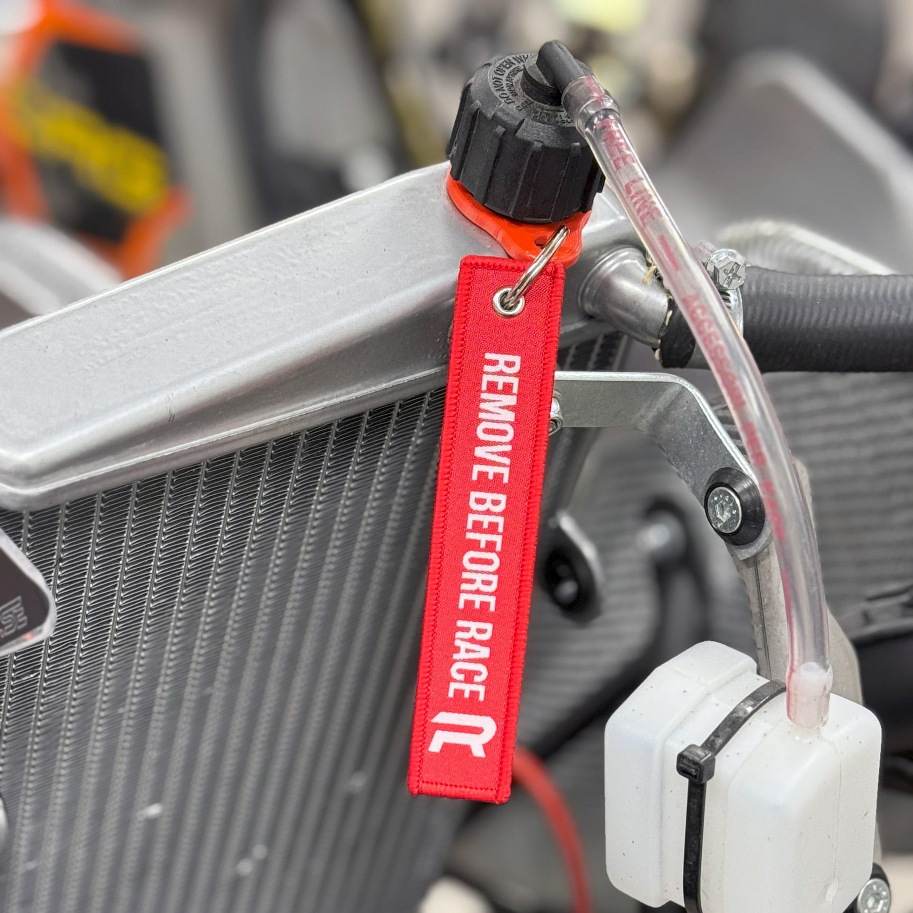 Radne Remove Before Race sangle radiateur rouge